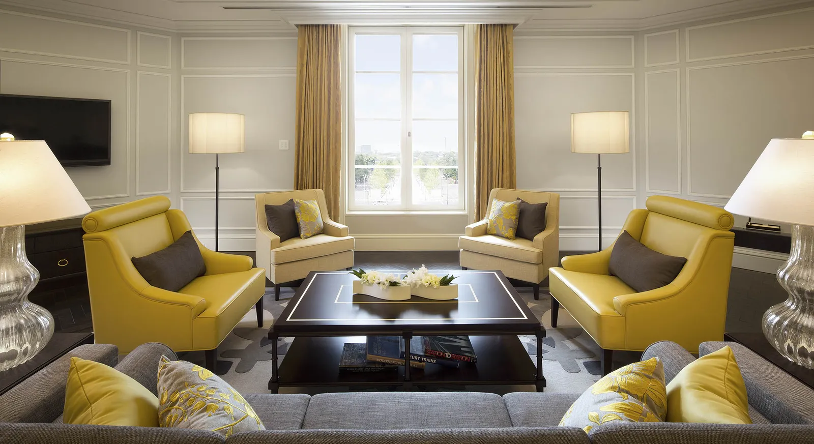 The Imperial Suite’s living room: yellow armchairs around a low table and the tall window.
