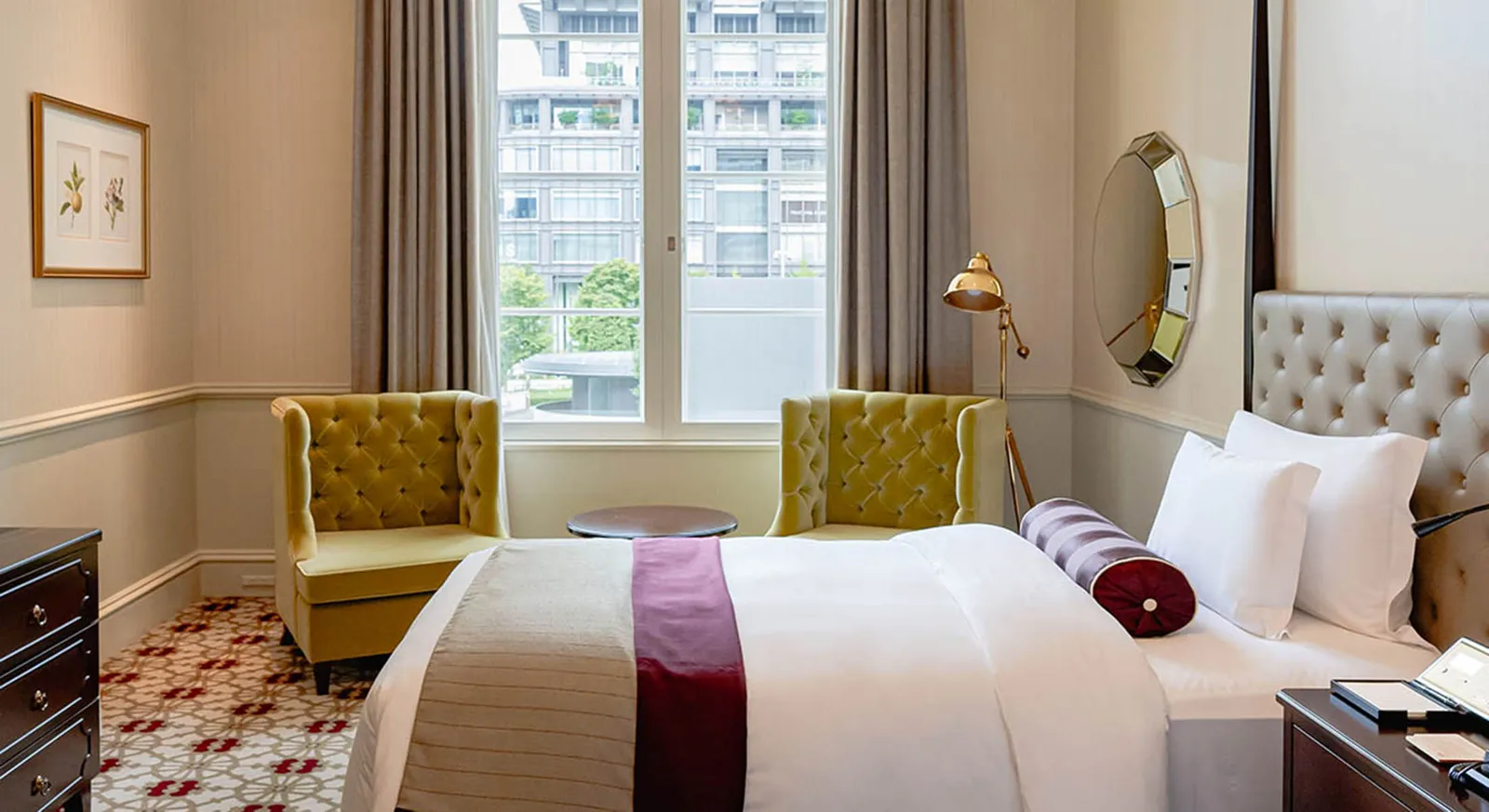 A Palace Side room with a large bed, 2 yellow armchairs at the window and a carpet with red flowers.