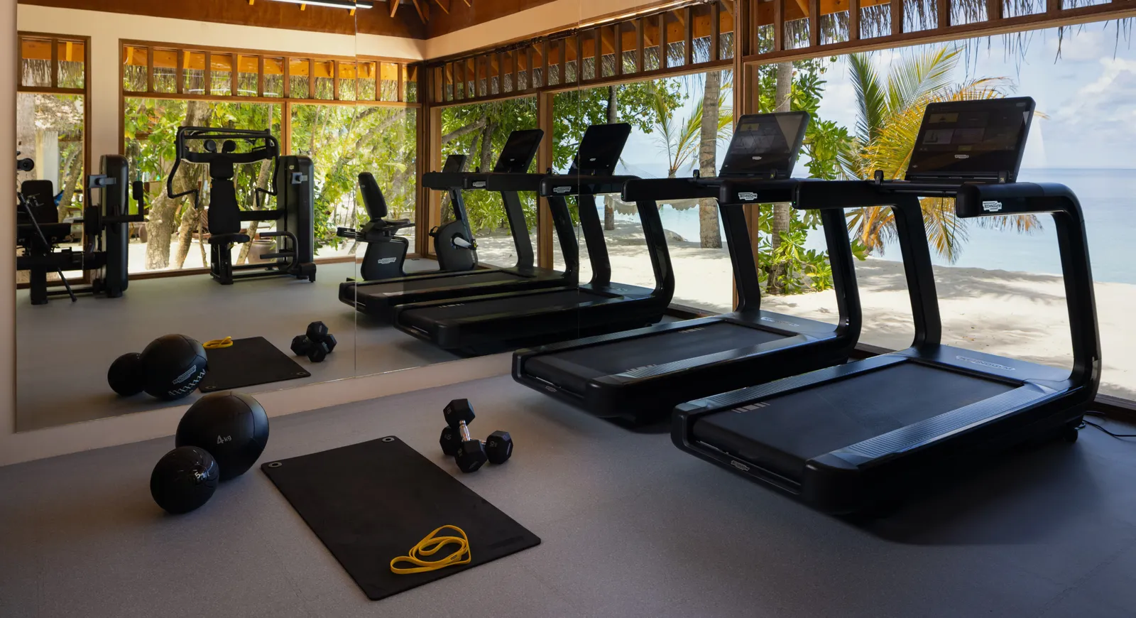 The gym, its treadmills and weights facing windows open onto the beach and the palms.