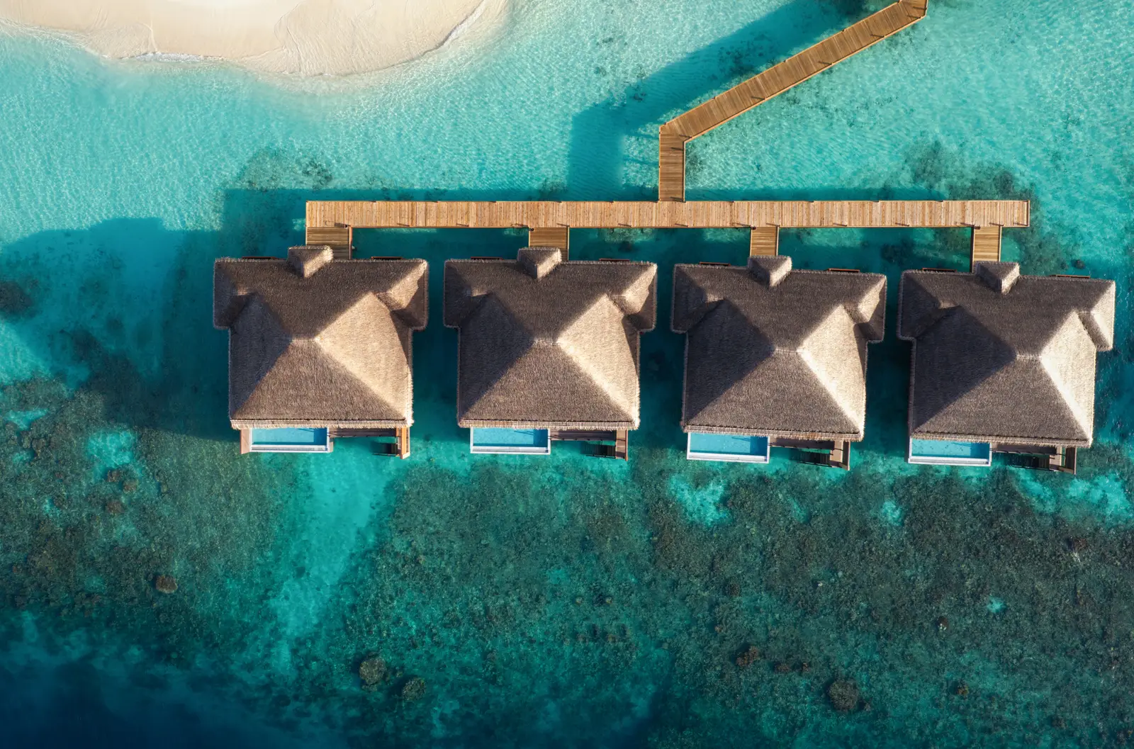 The 4 Two Bedroom Overwater Villas with Private Pool from above, in a row off the walkway, each with its own pool.