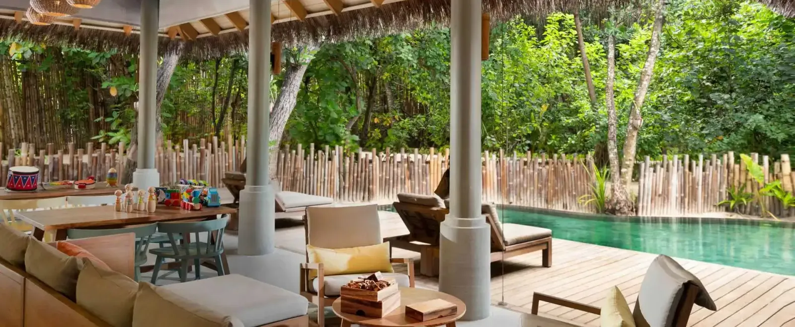 The Parrotfish Club’s terrace, with play tables and the children’s pool among the trees.
