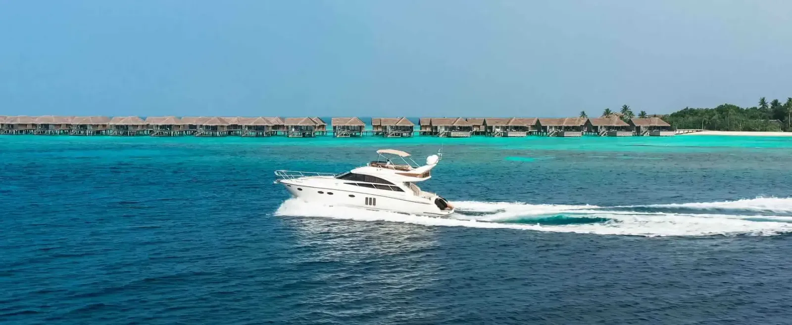The resort’s yacht passing the row of water villas.