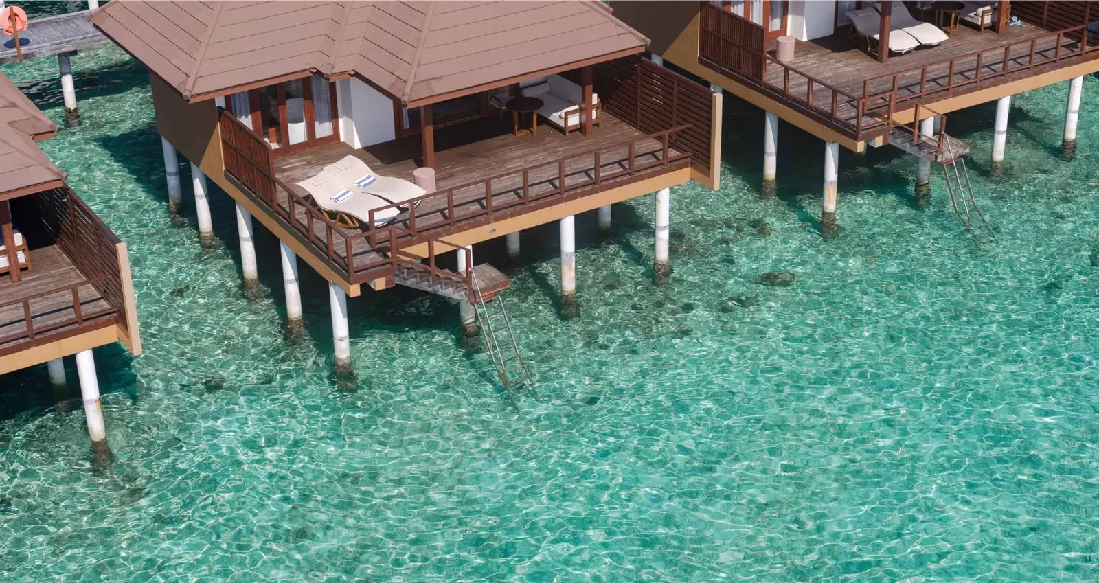 Water Villa decks from above, on stilts over the shallow, clear water of the lagoon.