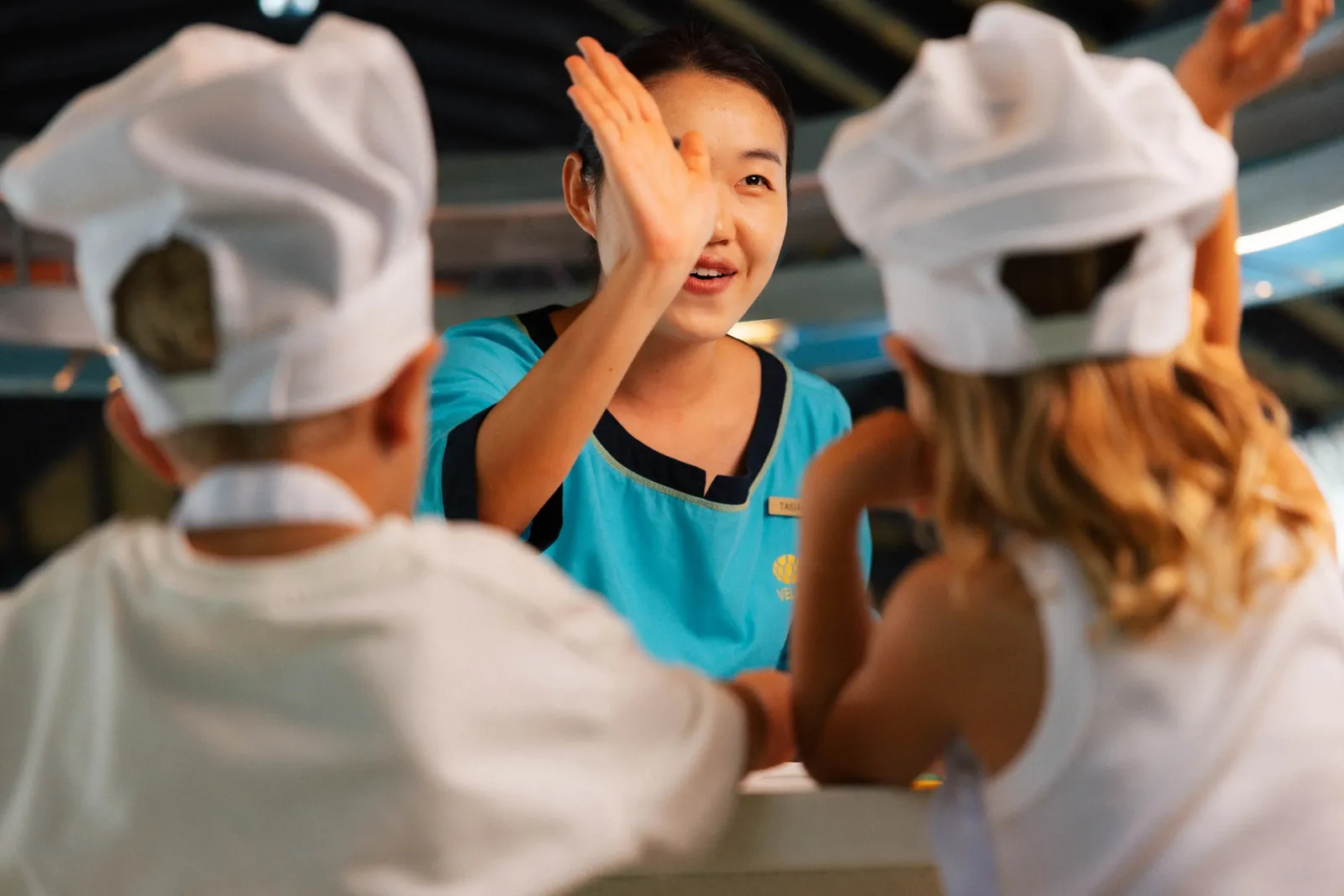 Children in chef’s hats laughing during a kids’ club session