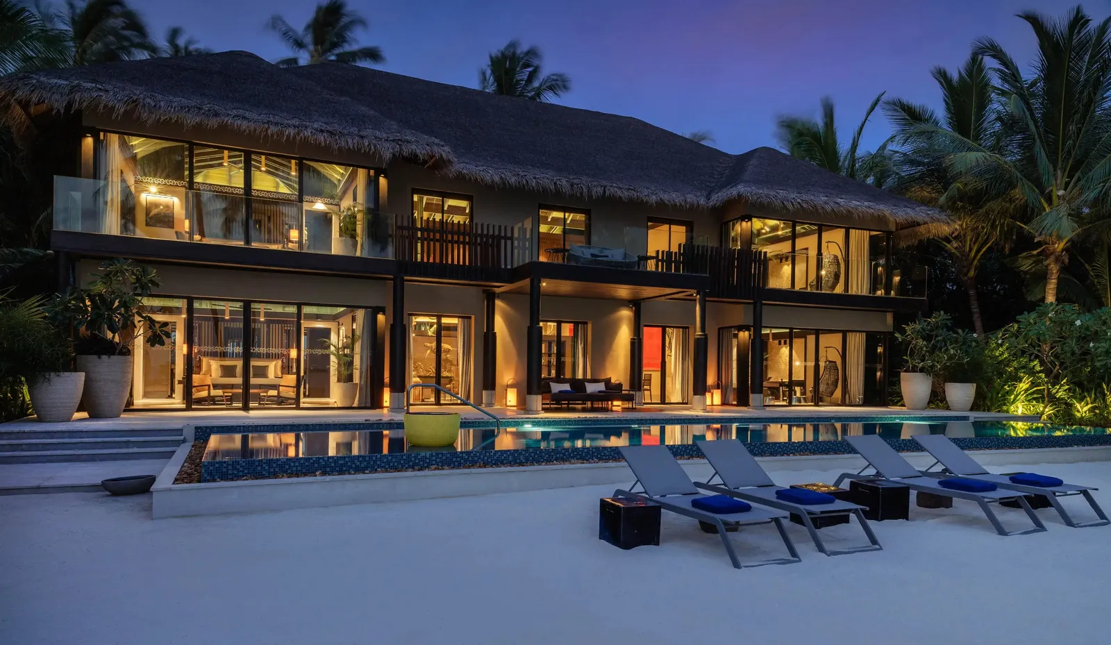 Funa Residence: the lit pavilion and the long pool on the beach