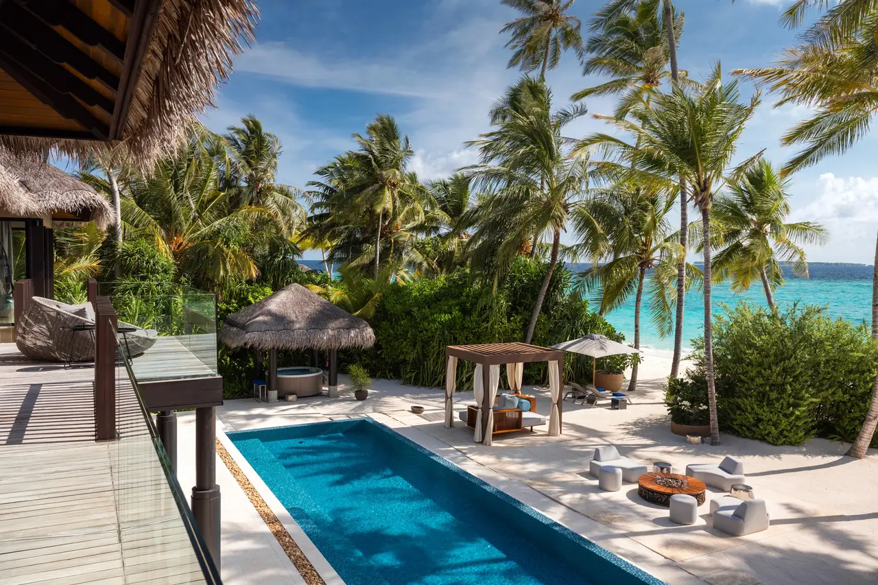 Nirolhu Residence: the pool and lawn among the palms facing the sea