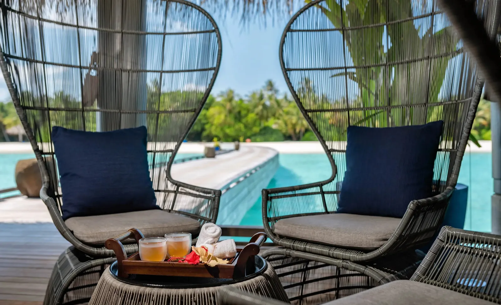 2 egg chairs on a spa terrace, the lagoon below