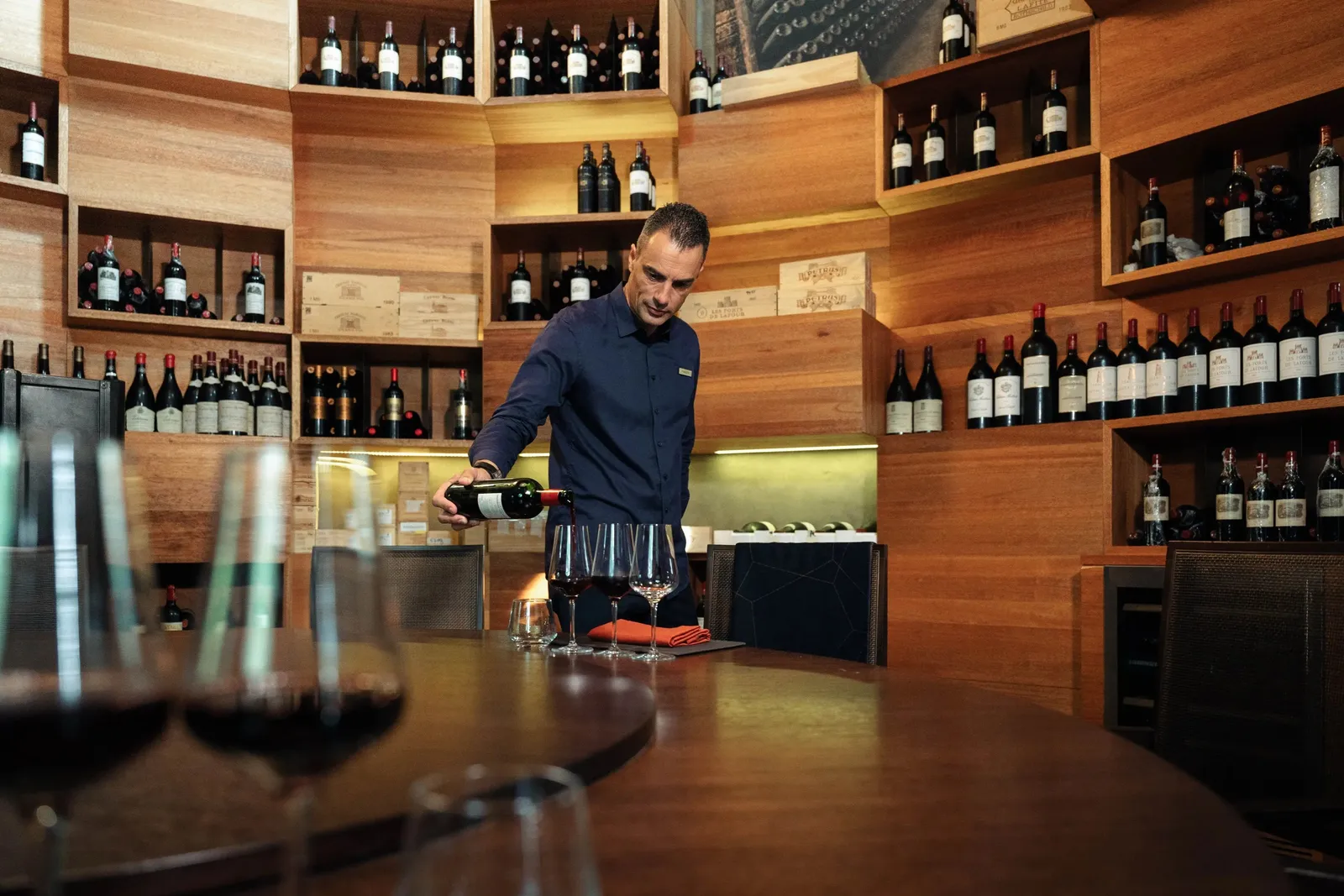 The wine cellar: shelves of bottles to the ceiling and a sommelier at the counter