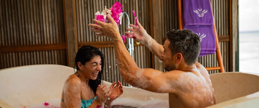 A couple laughing in a bath at Himeyn Spa.
