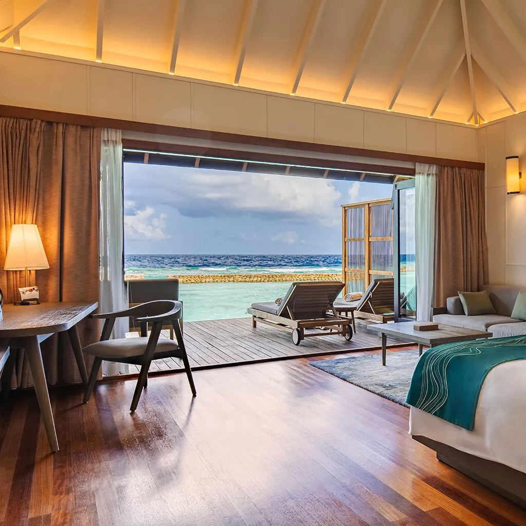 An Ocean Jacuzzi Villa bedroom, open to the deck and the sea.