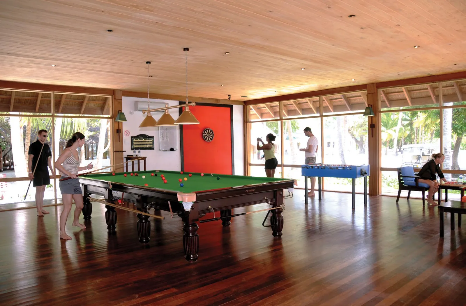 The games room, with the snooker table, table football, darts and windows onto the garden.