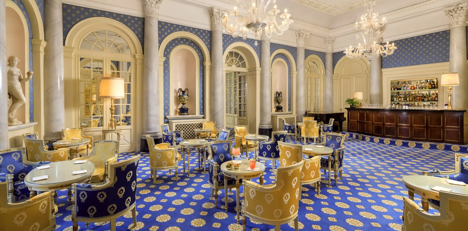 Bar Canova with blue carpet, gilt armchairs and chandeliers