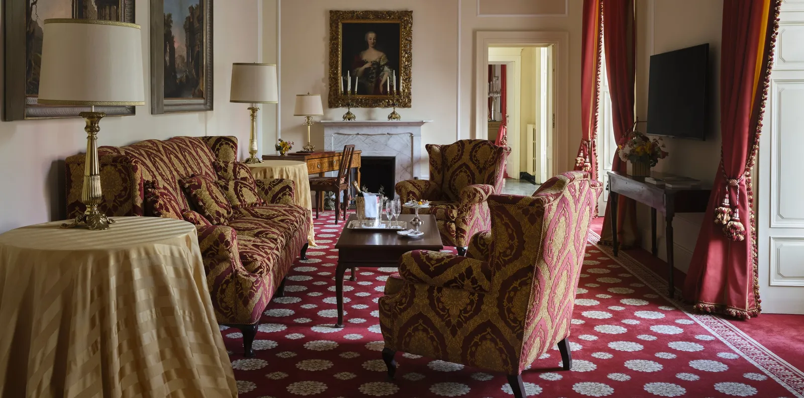 The Cardinal Suite’s sitting room with armchairs and a fireplace