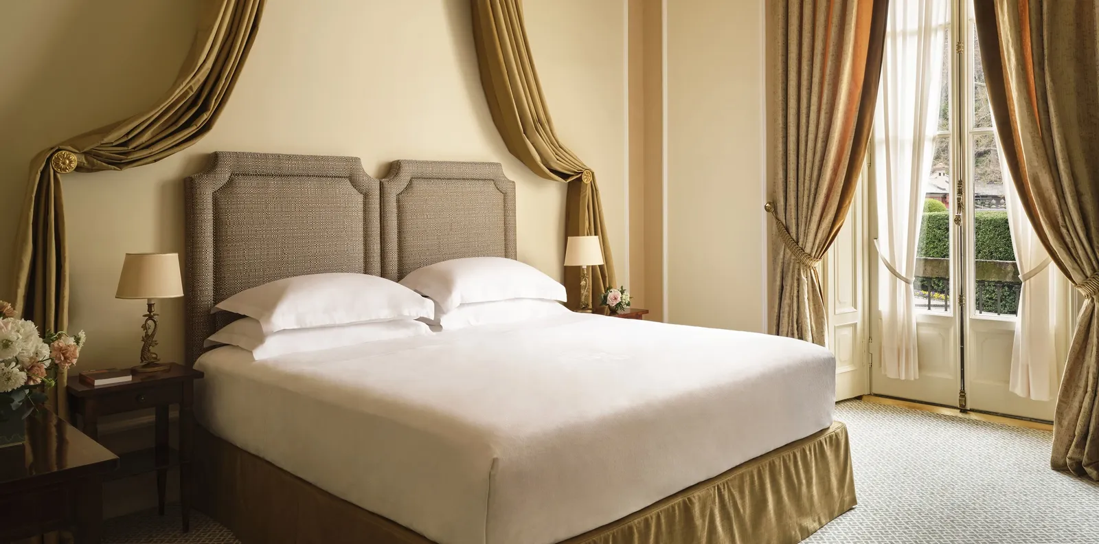 An Executive Room with the bed and tall windows