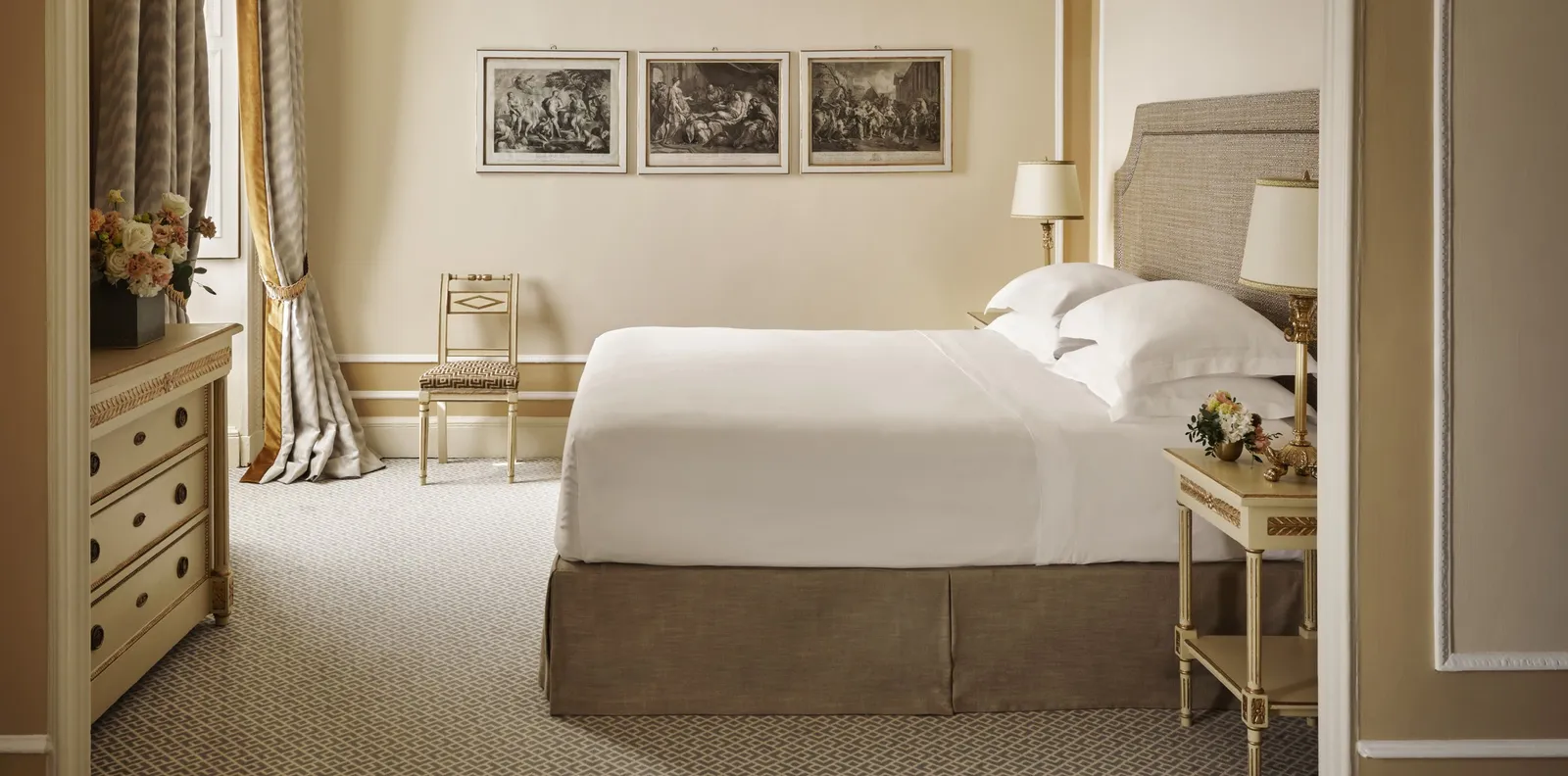 A Junior Suite Lake View Deluxe with the bed and prints on the walls