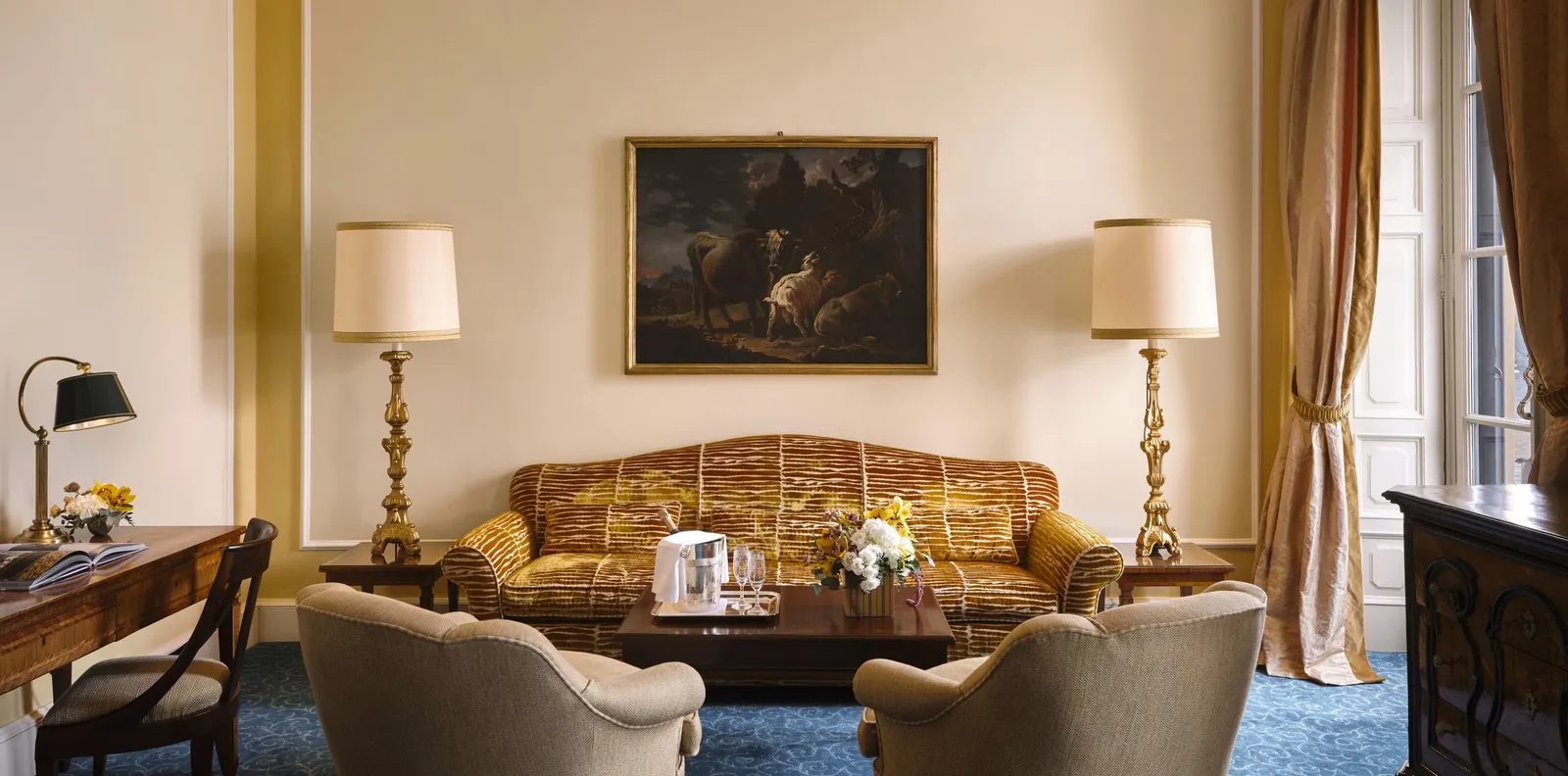 The Suite’s living room with a sofa and a painting
