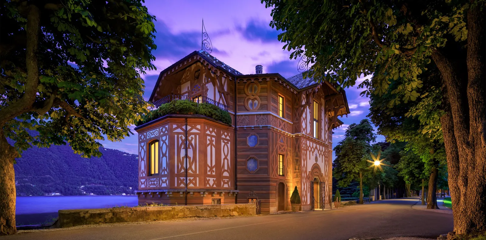 A villa lit at dusk among the park’s trees
