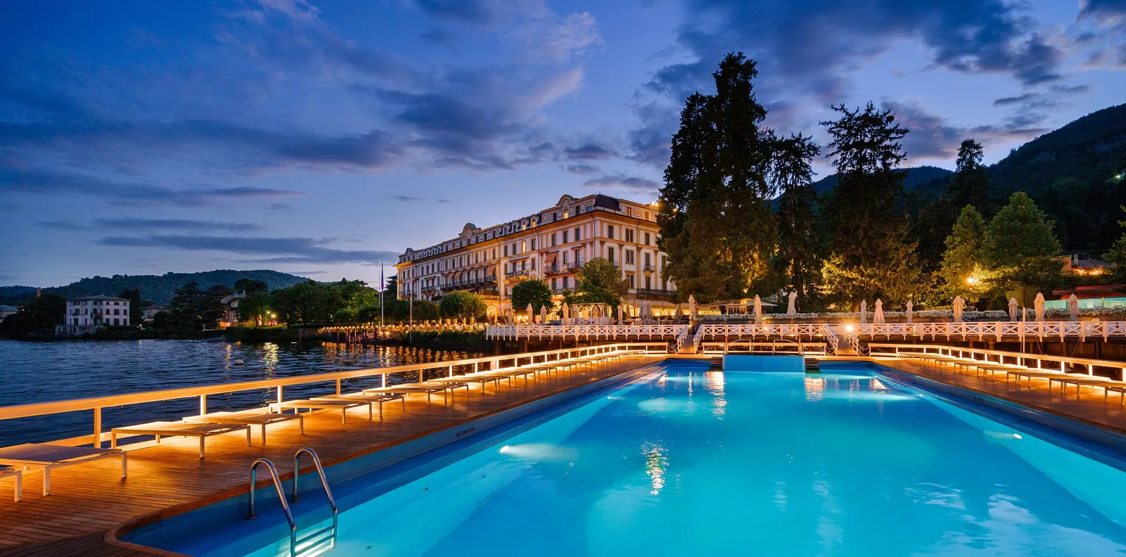 The floating pool at dusk with the hotel lit behind