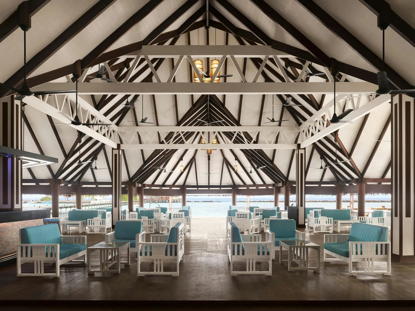 The Captain’s Bar under its white roof trusses, pale blue seating open to the lagoon.