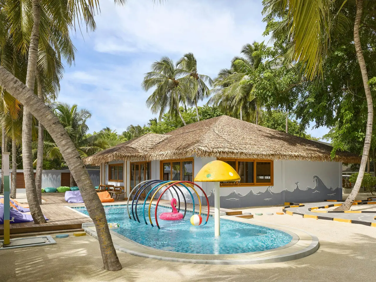 The Wavy Navy Kids Club among the palms, with its children’s pool, water arches and a yellow mushroom.