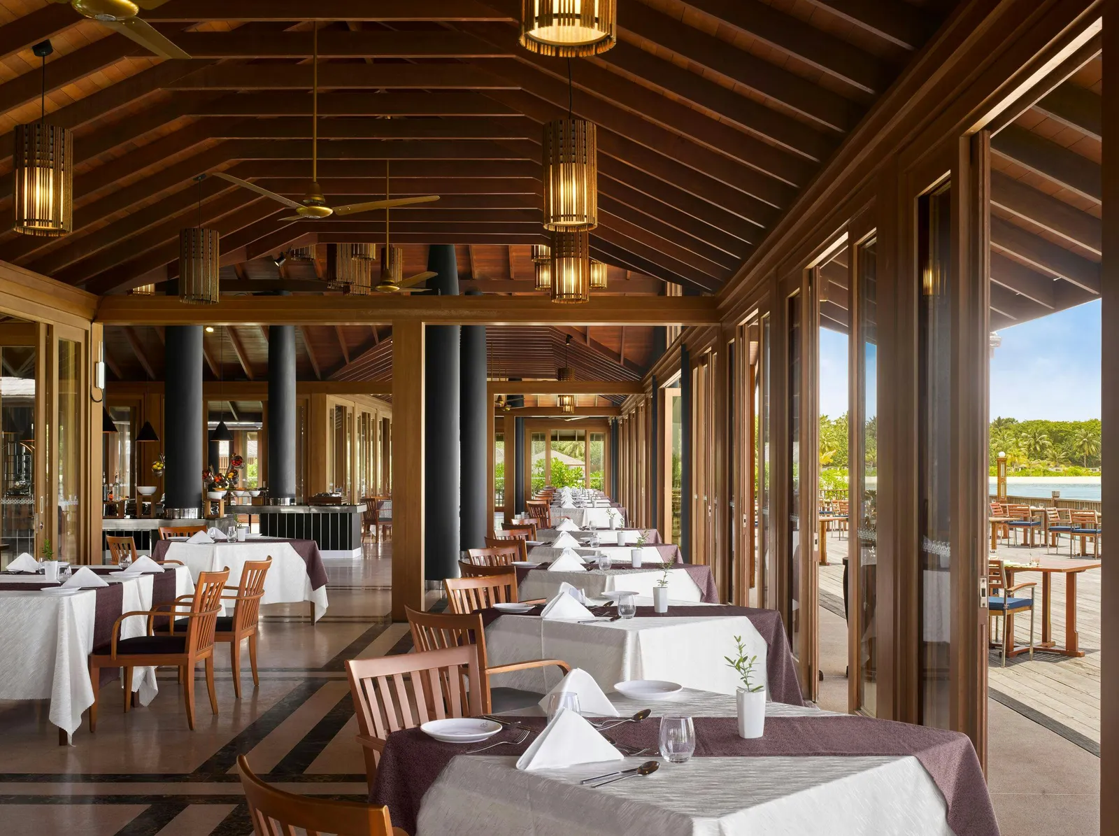 The Lagoon’s dining room by day, its glass doors open to the deck and the tables laid.