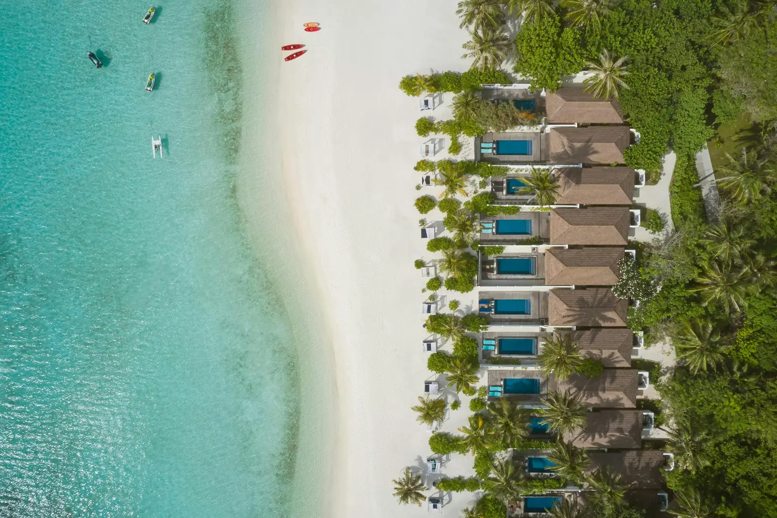 The row of Sunset Beach Pool Villas from above, each with its pool, along the sunset beach.