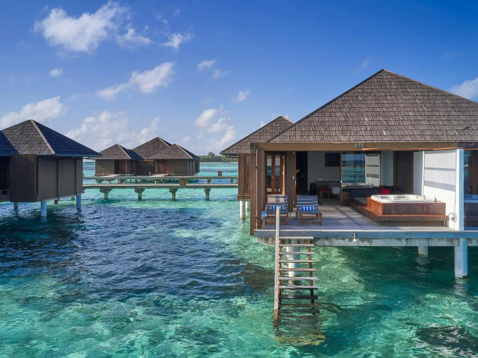 A Water Villa with Whirlpool on its stilts, the whirlpool on the deck and steps into the water.