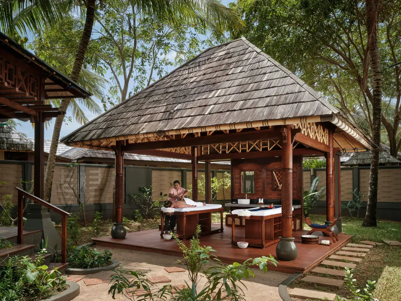 A couples’ treatment pavilion at Araamu Spa, under a wooden roof among the garden’s plants.