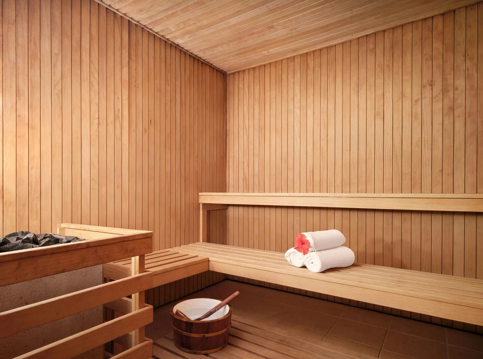 The wooden sauna at Araamu Spa, a bucket and towels on the bench.