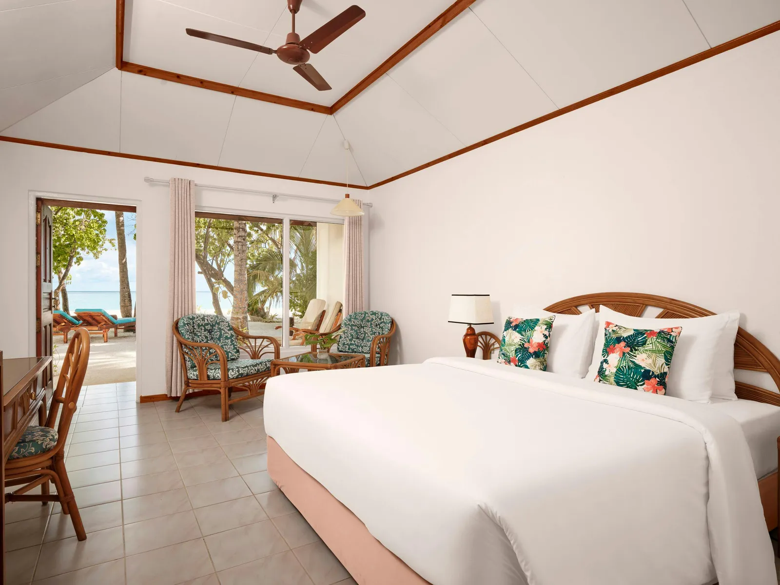 Beach Villa — Bedroom with bed, 2 chairs and open terrace doors.
