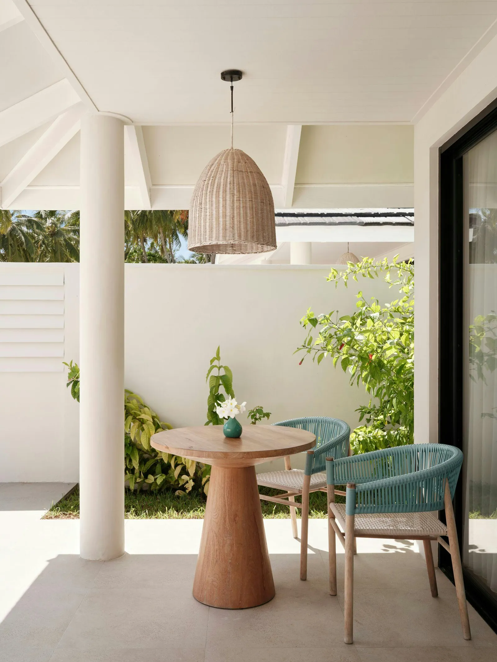 Beach Villa With Whirlpool — Covered terrace with 2 chairs, table and garden wall; whirlpool not visible.