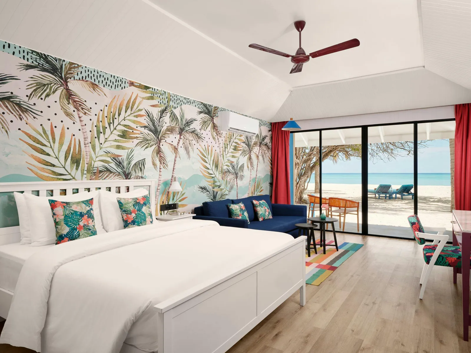 Colourful bedroom with doors towards the beach.