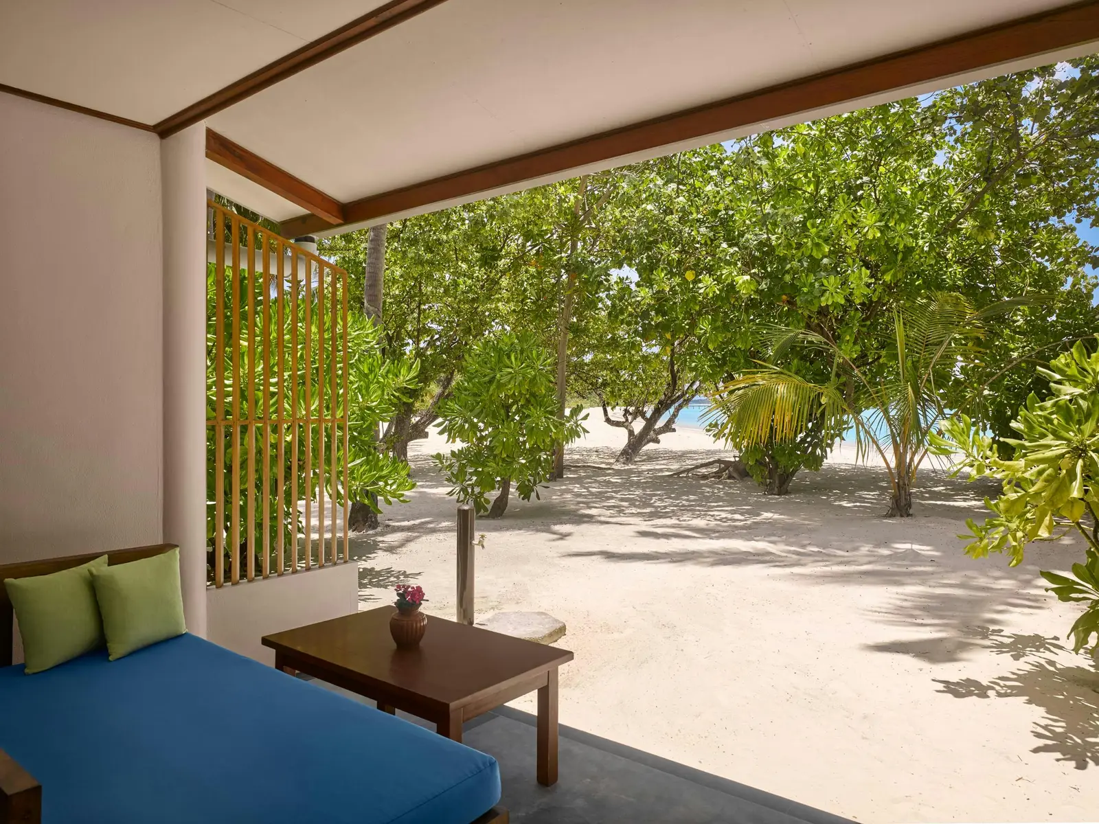 Sunset Beach Villa — Covered seating looking through trees towards beach.