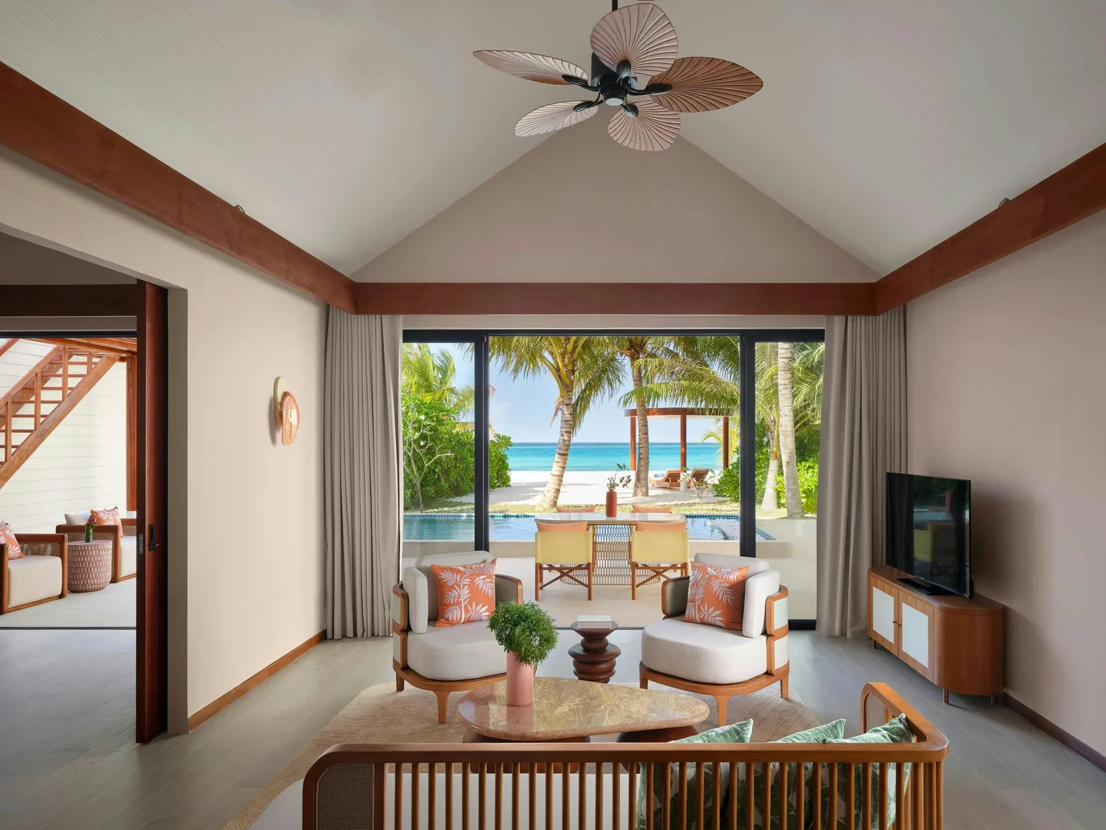 Residence living room looking through doors to garden, seating and sea.