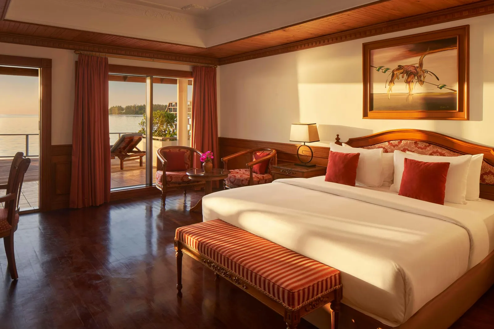 2 Bedroom Overwater Villa — Overwater bedroom with bed, bench, desk and sea-facing door.