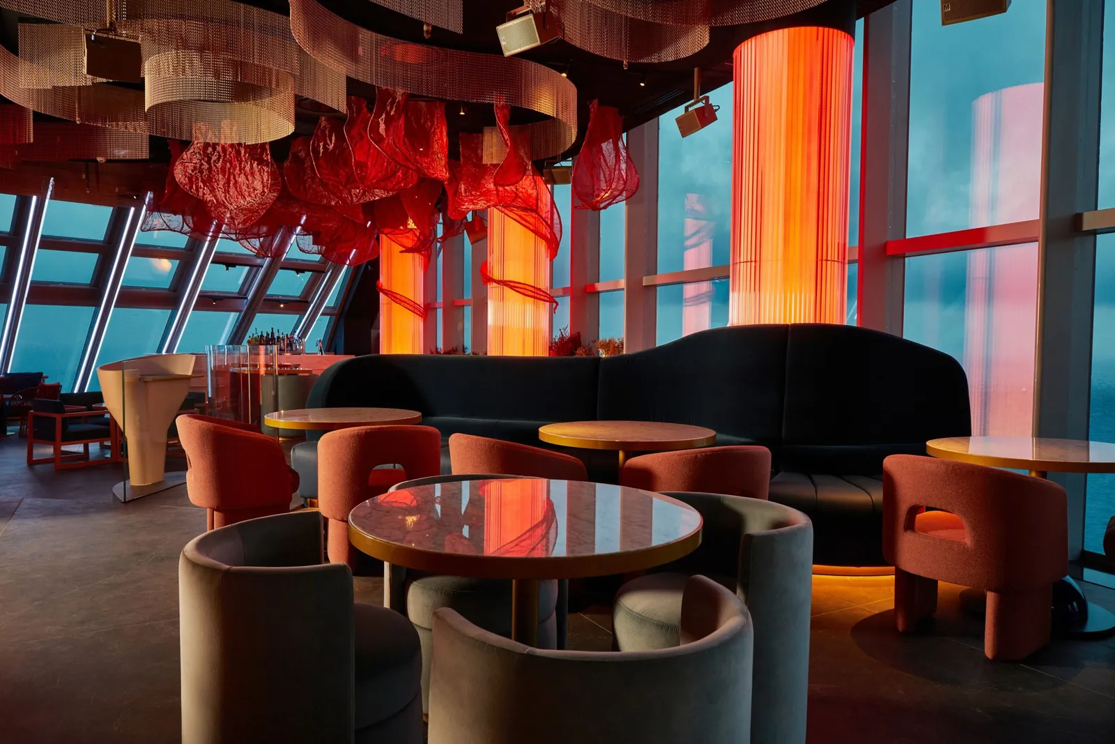NOXE’s lounge at night, between orange columns and red lamps