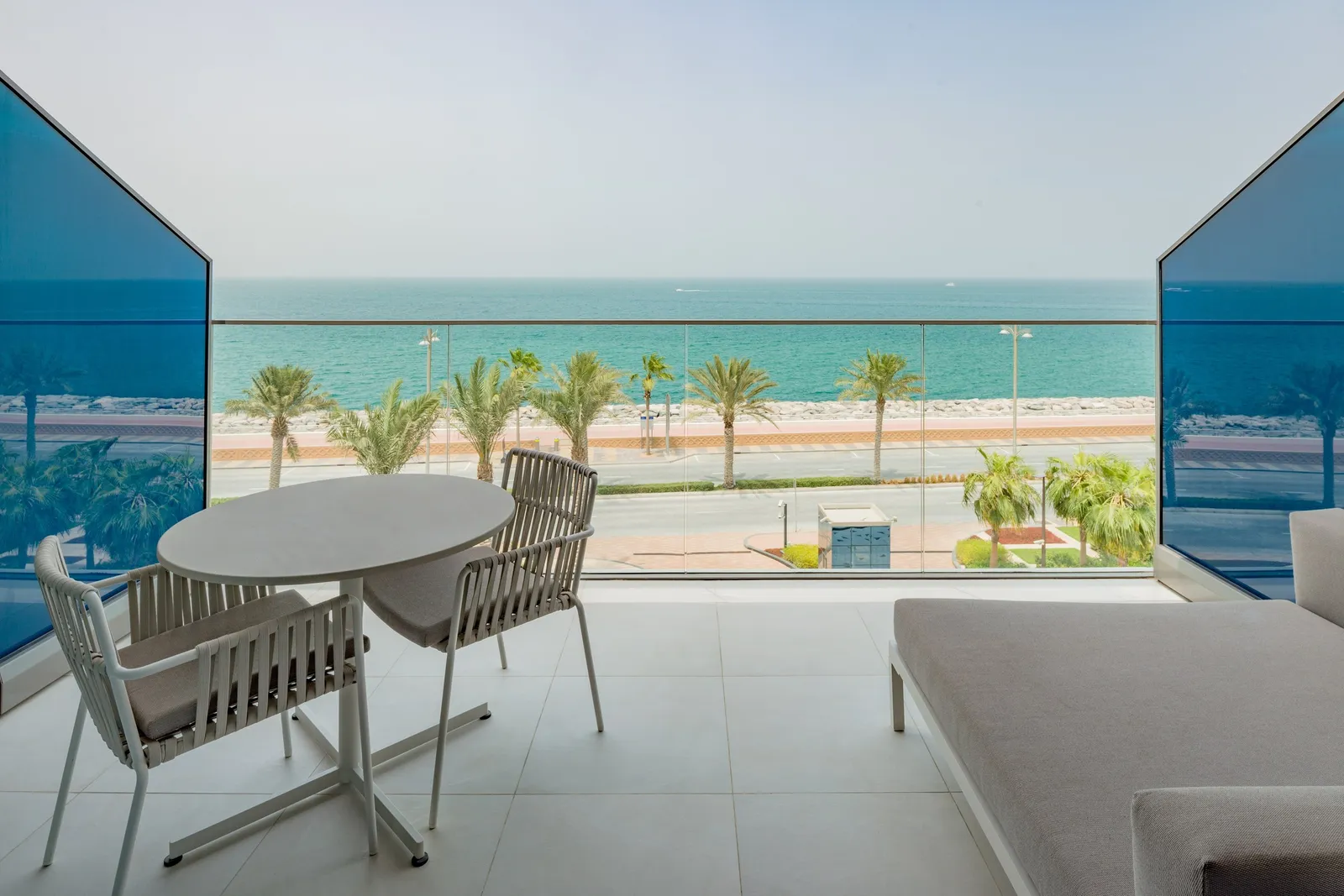A room balcony with its table and the sea ahead