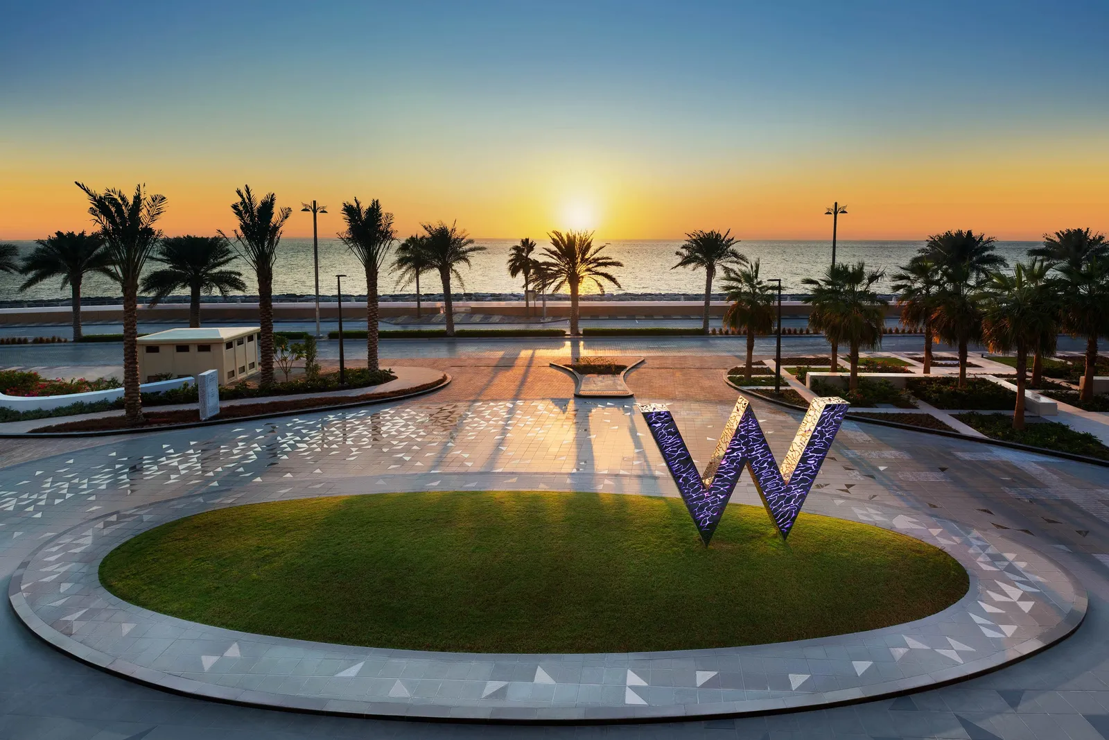 The big W on the lawn by the sea at sunset