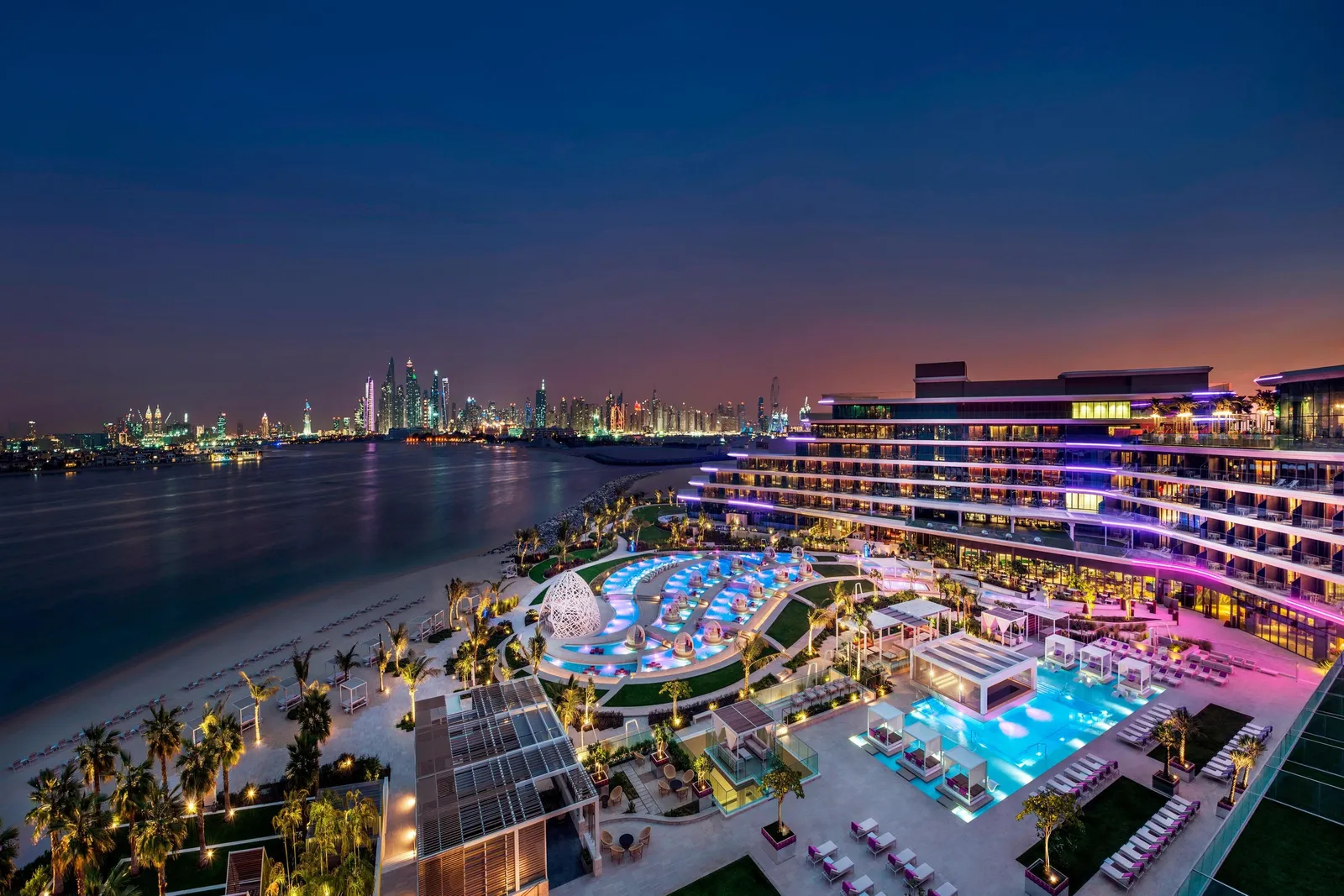 WET Deck’s wave-shaped pools lit up at night, from above