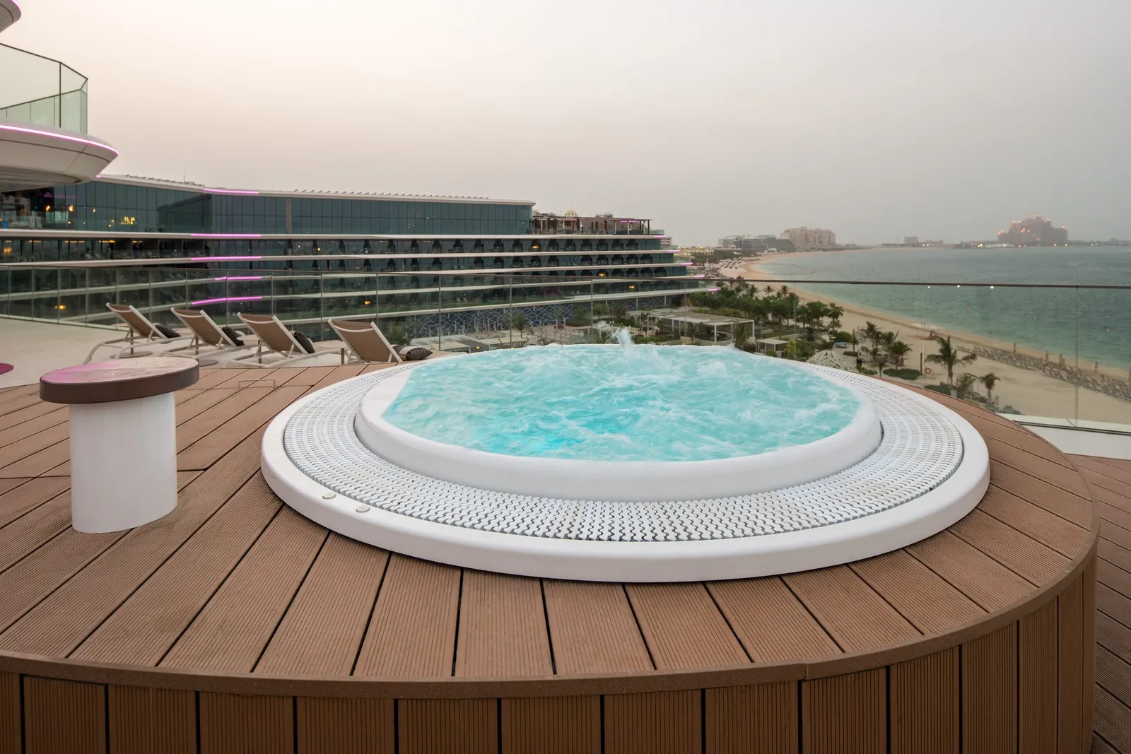 The E-WOW Suite whirlpool with its mosaic and a white armchair