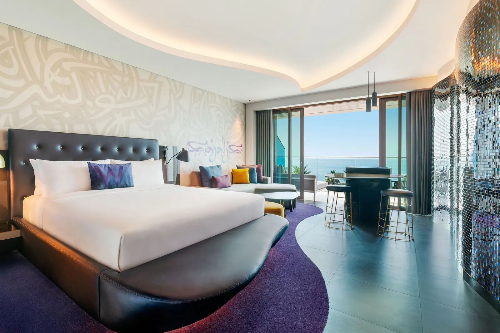 A Fabulous room with a king bed under the curved ceiling and the sea beyond the glass