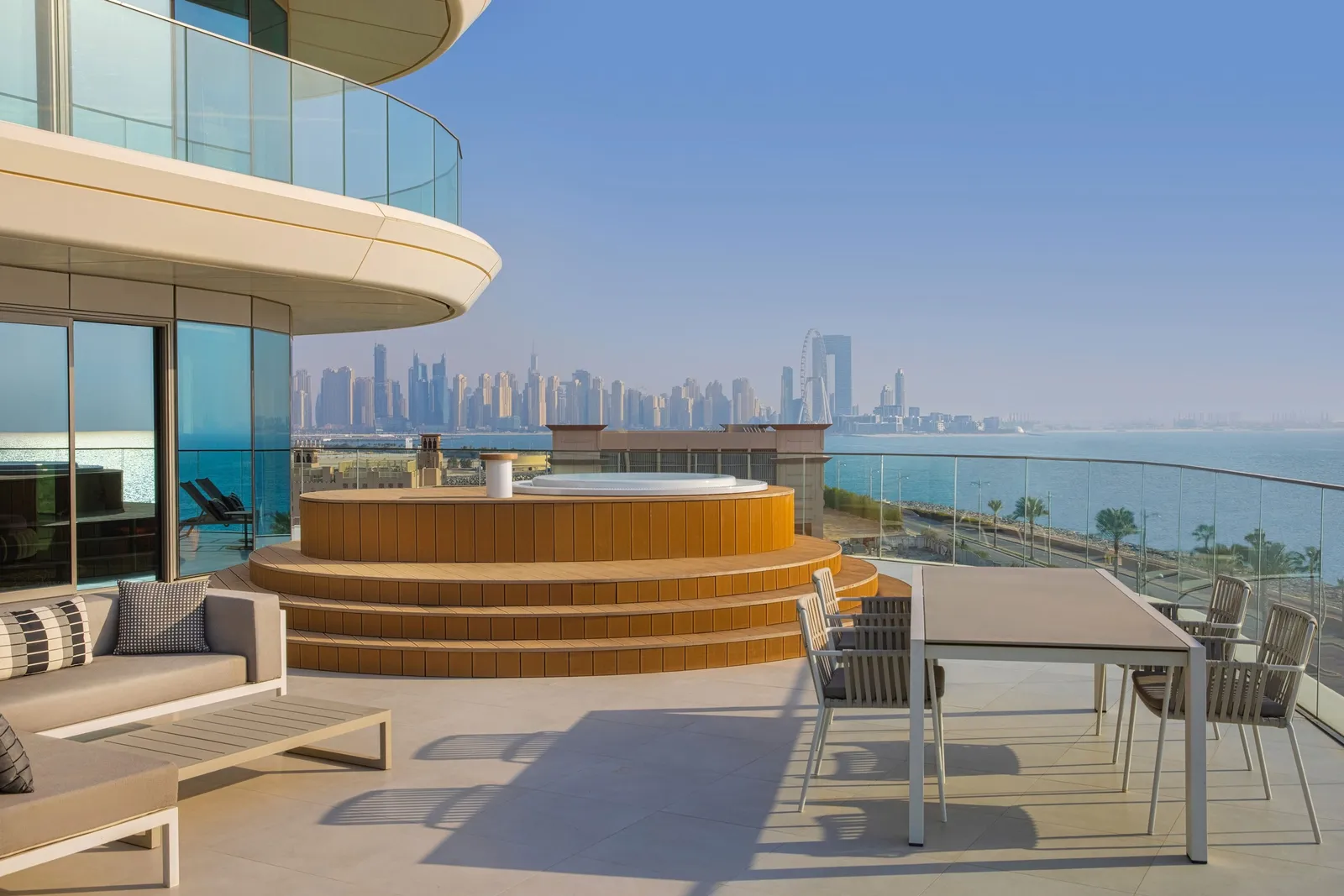 The suite terrace with a wooden whirlpool and loungers facing the sea