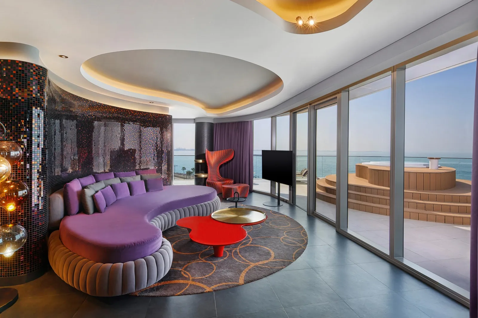 The Marvelous Suite living room with a purple sofa and glass onto the sea