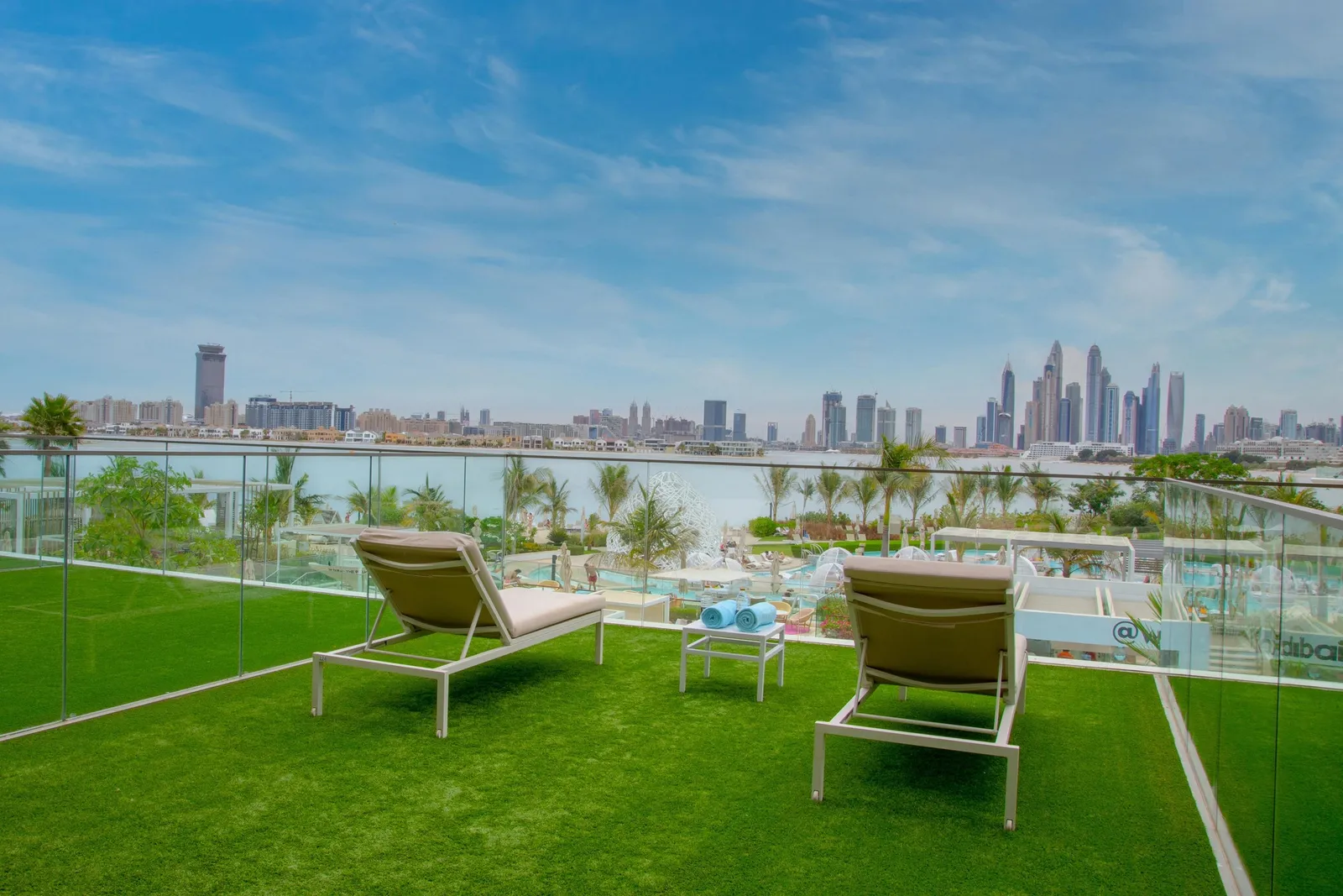 The terrace with its lawn and loungers, the Marina skyline across the water