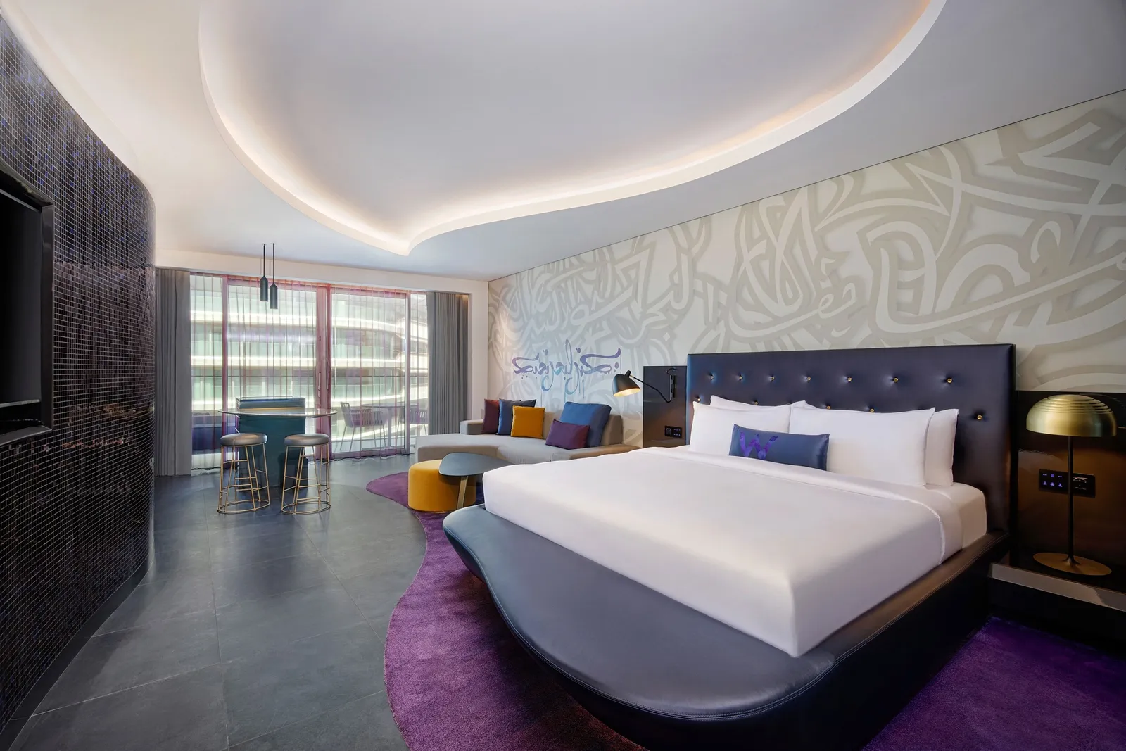 A Wonderful room with its white bed, a sofa and Arabic script on the wall