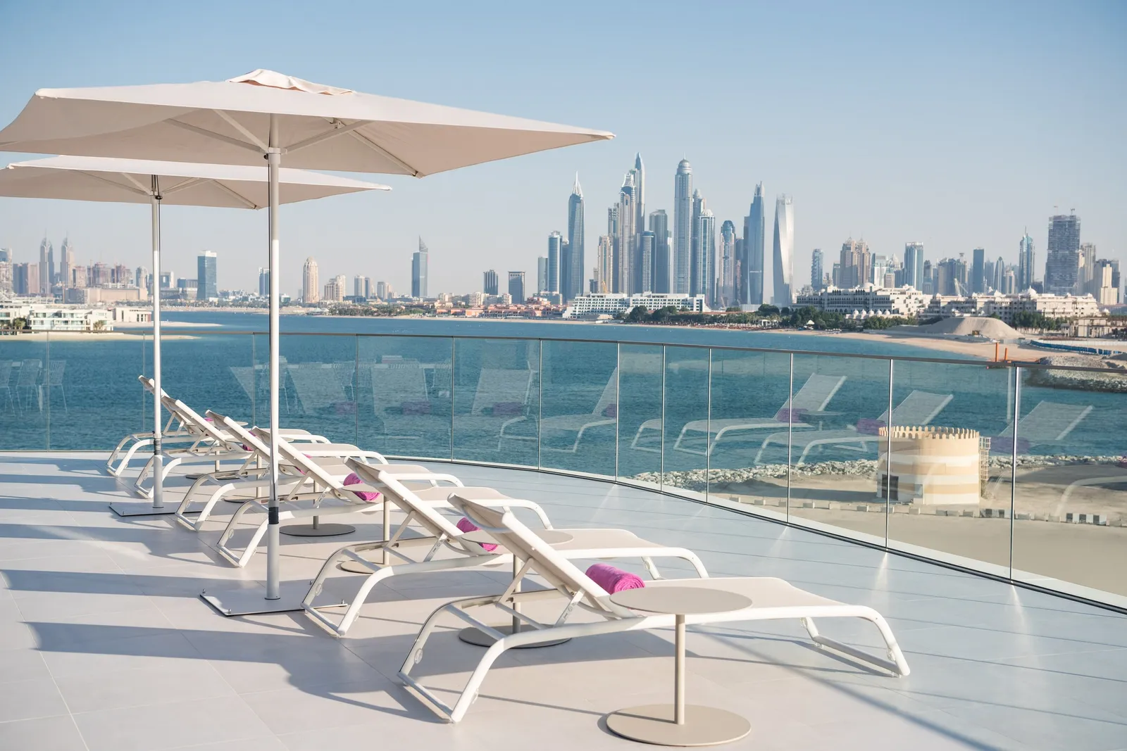 The WOW Suite terrace with loungers, a parasol and the Marina towers