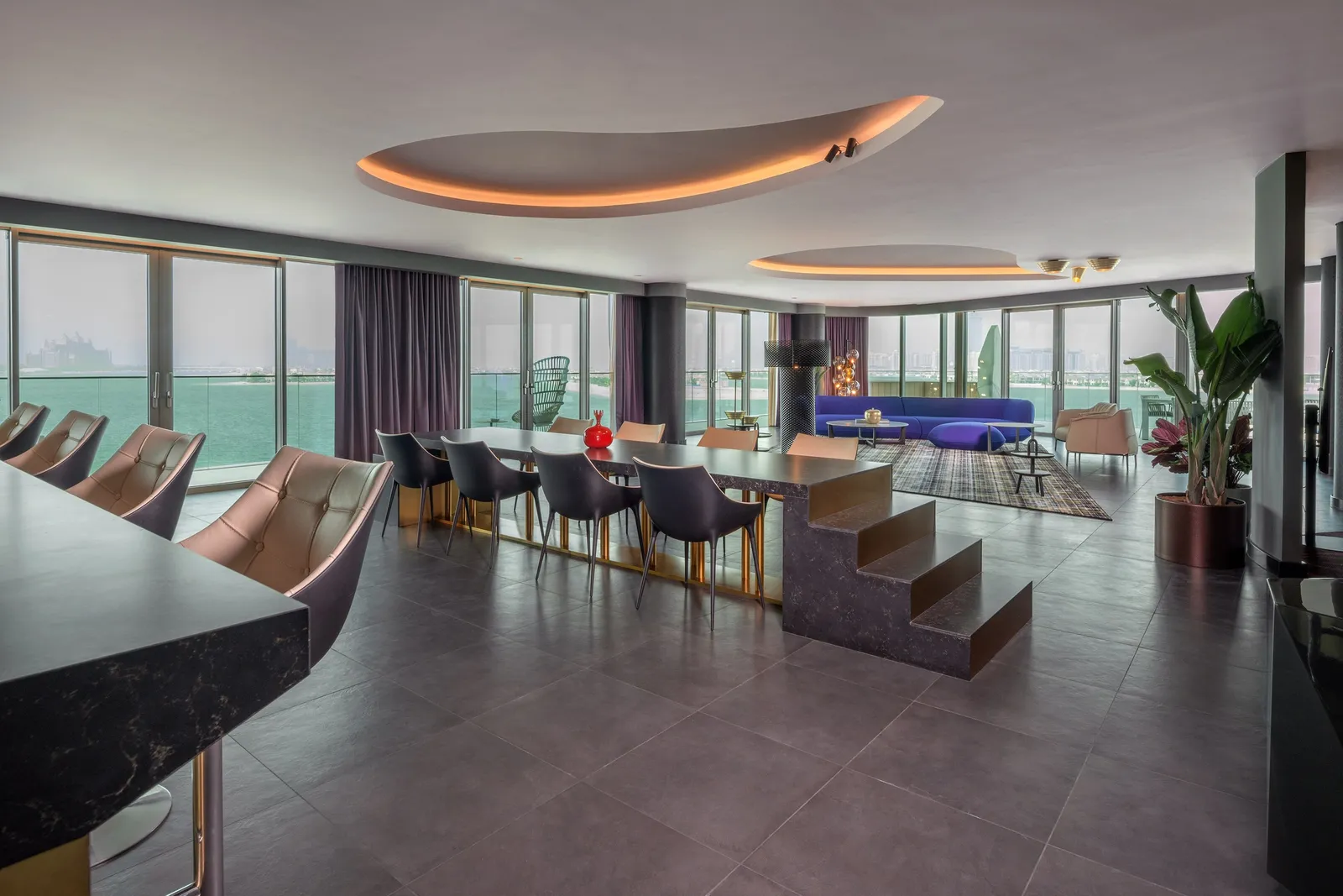 The WOW Suite living room with sofas and the city beyond the glass