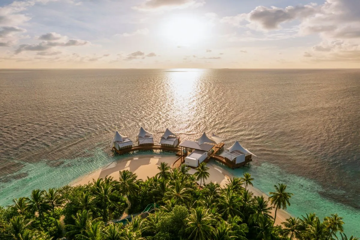 The overwater AWAY Spa pavilions at sunset