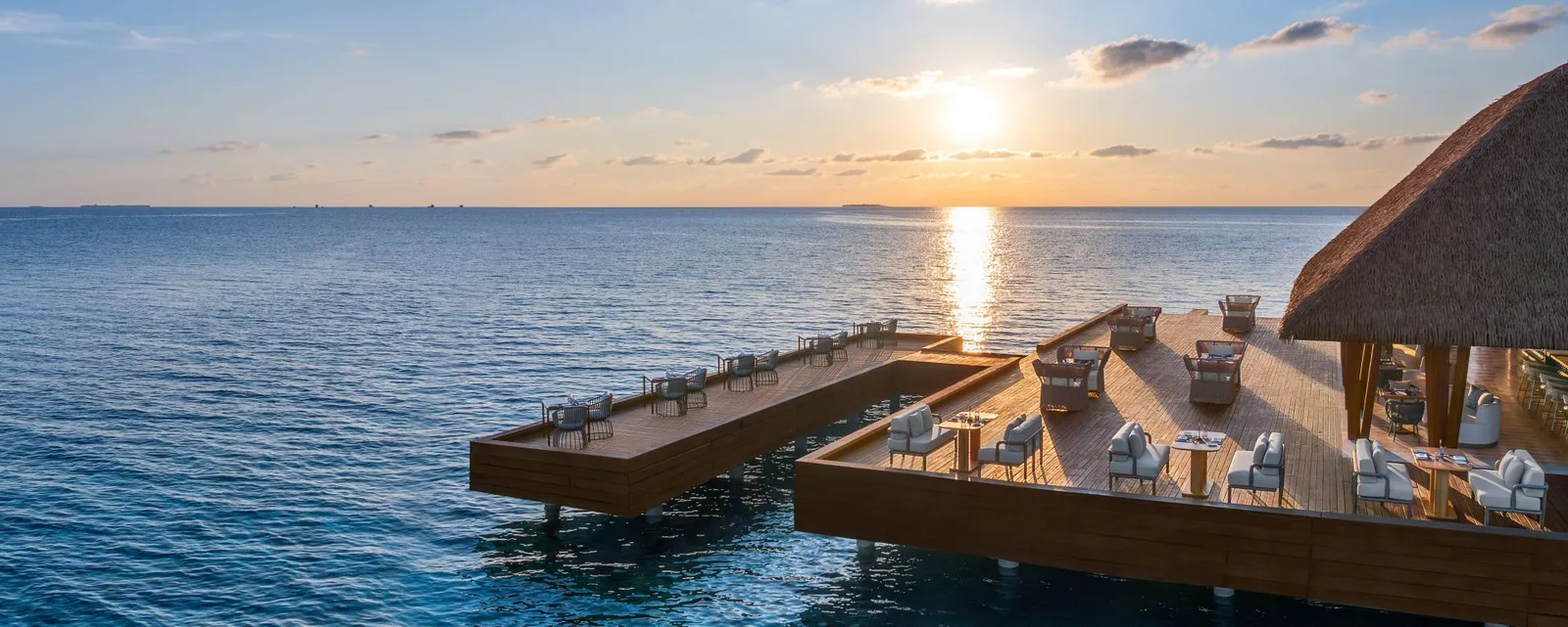 The FISH dining decks above the sea at sunset