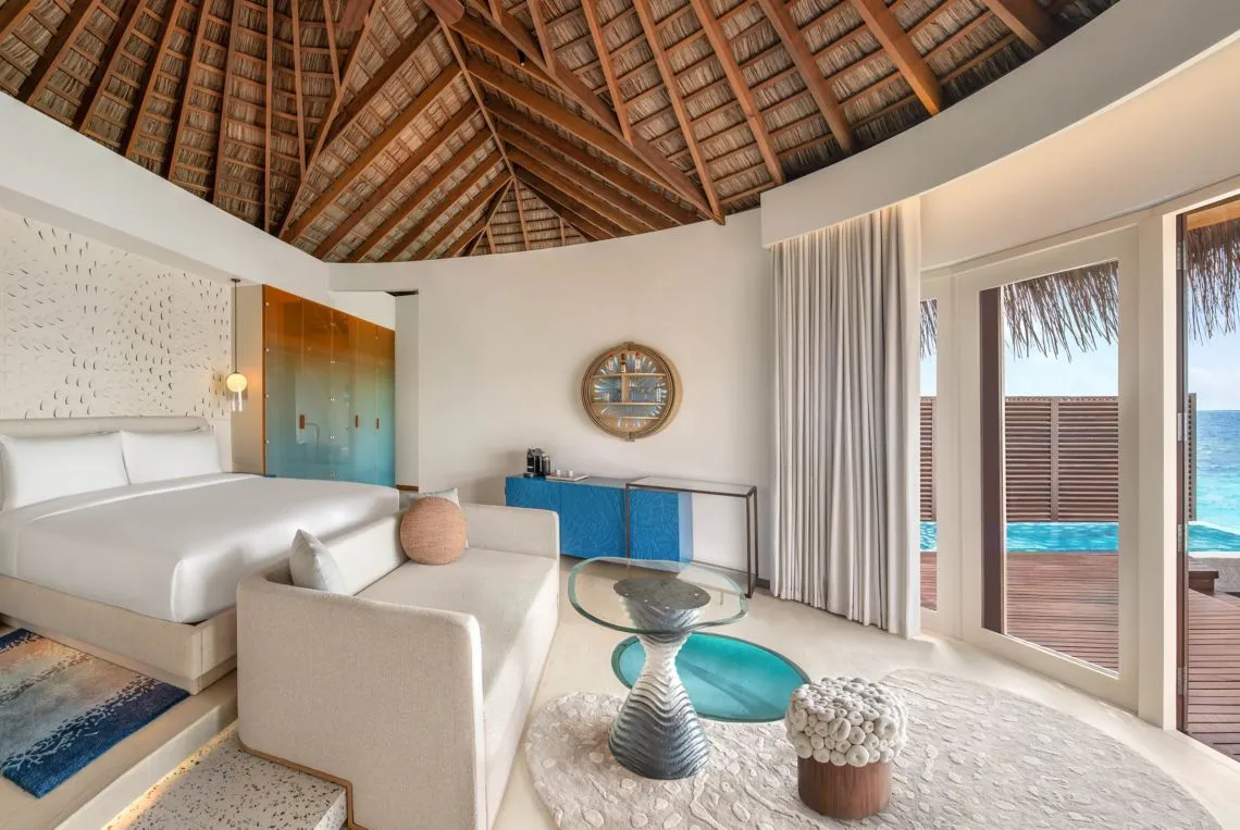 The Premier Overwater bedroom opening towards the deck and pool